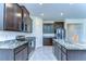 Stylish kitchen featuring dark wood cabinets, granite countertops, and stainless steel appliances at 5325 Thistle Field Ct, Wesley Chapel, FL 33545