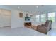 Bright living room with tile floors, plush rug, media center, and comfortable leather recliner near sunlit windows at 5325 Thistle Field Ct, Wesley Chapel, FL 33545