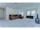 Spacious living room with a comfortable sectional sofa, futon, and natural light from the large windows at 5325 Thistle Field Ct, Wesley Chapel, FL 33545