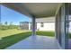 A covered patio looks out to a manicured backyard and screened-in porch at 5325 Thistle Field Ct, Wesley Chapel, FL 33545