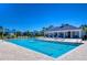Community swimming pool with lane markers, mature landscaping, lounge chairs and view of clubhouse at 5325 Thistle Field Ct, Wesley Chapel, FL 33545