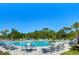 Large community pool with lounge chairs and palm trees at 5325 Thistle Field Ct, Wesley Chapel, FL 33545
