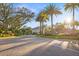 Elegant gated community entrance with lush landscaping, palm trees and a welcoming guard house at 5950 Pelican Bay S Plz # 603, Gulfport, FL 33707