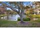 Scenic view of a tranquil pond reflecting the surrounding trees and a multi-story building at 5950 Pelican Bay S Plz # 603, Gulfport, FL 33707