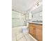 Bathroom featuring shower with sliding glass door, wood cabinet, granite counter and tile floors at 601 N Keene Rd # P9, Clearwater, FL 33755