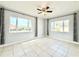 Bright bedroom featuring tile flooring, ceiling fan, two large windows and neutral paint at 601 N Keene Rd # P9, Clearwater, FL 33755