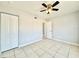 Cozy bedroom features tile flooring, ceiling fan, closet and neutral paint at 601 N Keene Rd # P9, Clearwater, FL 33755