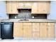 Well-lit kitchen featuring wood cabinets, granite counters, and black appliances at 601 N Keene Rd # P9, Clearwater, FL 33755