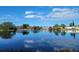 Scenic lake view reflecting blue skies, mature trees, and community buildings at 601 N Keene Rd # P9, Clearwater, FL 33755