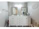 Bathroom with double sink vanity, decorative mirrors, patterned floor tiles, and unique wall decorations at 6311 Bayside Dr, New Port Richey, FL 34652
