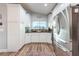 Well-lit kitchen featuring white cabinets, stainless steel appliances, and a window overlooking the outdoors at 6311 Bayside Dr, New Port Richey, FL 34652