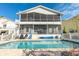 A beautiful pool with clear water, a blue sky and a white picket fence at 6311 Bayside Dr, New Port Richey, FL 34652