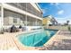 Backyard pool features brick patio, screened lanai, and white aluminum fencing at 6311 Bayside Dr, New Port Richey, FL 34652