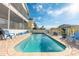 A blue pool with clear water, a blue sky and a white picket fence at 6311 Bayside Dr, New Port Richey, FL 34652