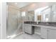 Bright bathroom featuring a glass shower, granite counters, and dual sinks at 6827 Citrus Creek Ln, Tampa, FL 33625