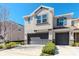Attractive townhome featuring a two-car garage, neutral stucco, manicured landscaping, and a classic architectural design at 6827 Citrus Creek Ln, Tampa, FL 33625