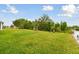 Expansive backyard showcases lush green grass and mature trees offering privacy at 6882 Silverado Ranch Blvd, Zephyrhills, FL 33541
