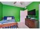 Colorful bedroom with green walls, modern fixtures and a television at 6882 Silverado Ranch Blvd, Zephyrhills, FL 33541