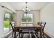 Bright dining room featuring elegant chandelier, slider door to backyard and stylish table and chairs at 6882 Silverado Ranch Blvd, Zephyrhills, FL 33541