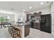 Spacious kitchen with granite countertops, dark cabinets, and an island with seating at 6882 Silverado Ranch Blvd, Zephyrhills, FL 33541
