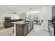 Open kitchen with granite countertops and breakfast bar overlooking the living room and dining area at 6882 Silverado Ranch Blvd, Zephyrhills, FL 33541