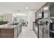 Modern kitchen featuring granite countertops, stainless appliances, and a view of the dining and living areas at 6882 Silverado Ranch Blvd, Zephyrhills, FL 33541