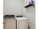 Laundry room featuring a washer, dryer, and shelf for laundry supplies at 6882 Silverado Ranch Blvd, Zephyrhills, FL 33541