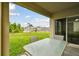 Relaxing covered patio with an outdoor table and chairs, overlooking a well-maintained backyard at 6882 Silverado Ranch Blvd, Zephyrhills, FL 33541