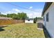 Expansive backyard with lush grass, a privacy fence, and a storage shed, perfect for outdoor activities at 7520 Orpine N Dr, St Petersburg, FL 33702