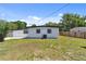 Lush backyard with green grass, privacy fence, and view of the home's rear exterior at 7520 Orpine N Dr, St Petersburg, FL 33702