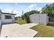Spacious backyard featuring grass, a shed, and concrete patio area for outdoor enjoyment at 7520 Orpine N Dr, St Petersburg, FL 33702