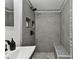 Modern tiled shower with pebble floor and built-in shower caddy at 7520 Orpine N Dr, St Petersburg, FL 33702