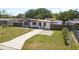 Beautifully landscaped front yard featuring a well-maintained lawn and attractive fencing at 7520 Orpine N Dr, St Petersburg, FL 33702