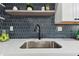 Close up of the kitchen sink with new countertops, modern faucet, backsplash, and natural light at 7520 Orpine N Dr, St Petersburg, FL 33702