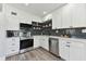 Modern kitchen featuring stainless steel appliances, white cabinets, stylish backsplash, and quartz countertops at 7520 Orpine N Dr, St Petersburg, FL 33702