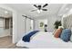 A modern main bedroom with white walls, wood floors, and a ceiling fan at 7520 Orpine N Dr, St Petersburg, FL 33702