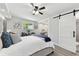 Spacious main bedroom featuring a large bed, vanity area, and a barn door leading to the bathroom at 7520 Orpine N Dr, St Petersburg, FL 33702