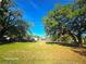Large property lot with mature trees and lush grass under a bright blue sky at 851 Easy St, Brooksville, FL 34601