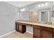 Bathroom boasts double vanity, granite countertop and a large mirror and walk in shower at 8529 Hunters Fork Loop, Ruskin, FL 33573