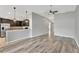 Living room features wood floors, ceiling fan, and connects to the kitchen at 8529 Hunters Fork Loop, Ruskin, FL 33573