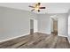 Main bedroom with ensuite bathroom, wood floor, ceiling fan, and neutral paint at 8529 Hunters Fork Loop, Ruskin, FL 33573