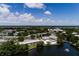 An aerial view of the community, pool, and a large body of water in the background under a partly cloudy sky at 8555 112Th St # 209, Seminole, FL 33772