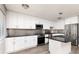 Modern kitchen with white cabinetry, stainless steel appliances, and a center island with black countertops at 8555 112Th St # 209, Seminole, FL 33772
