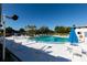 A large community pool surrounded by lounge chairs and lush greenery under a clear blue sky for relaxation and enjoyment at 8555 112Th St # 209, Seminole, FL 33772