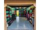 Finished garage with blue floor, fitness equipment, and an open door to a lush green landscape at 10216 Seminole Island Dr, Largo, FL 33773