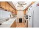Bright kitchen features laminate flooring, vaulted ceiling, wood cabinets and white appliances at 10216 Seminole Island Dr, Largo, FL 33773