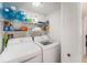 Bright laundry room with a washer, dryer and storage shelves for supplies at 10216 Seminole Island Dr, Largo, FL 33773
