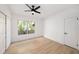Bright bedroom with wood floors, a ceiling fan, a large window, and a closet for storage at 104 W South Ave, Tampa, FL 33603