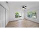 Light-filled bedroom featuring hardwood floors, a ceiling fan, and a double window with lush outdoor views at 104 W South Ave, Tampa, FL 33603