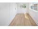 Bright empty room featuring light wood flooring and a white door with black hardware at 104 W South Ave, Tampa, FL 33603